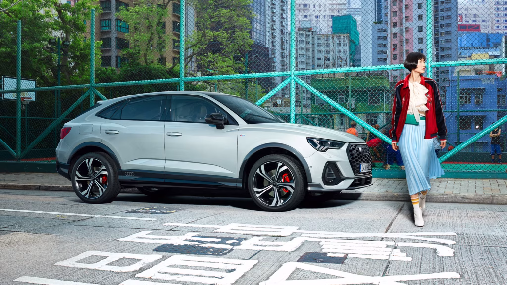 Audi Q3 sportback 2025 en un ambiente urbano con una mujer cruzando la calle